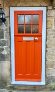 Orange traditional wooden front door 